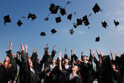Newly Graduated People Wearing Black Academy Gowns Throwing Hats Up in the Air